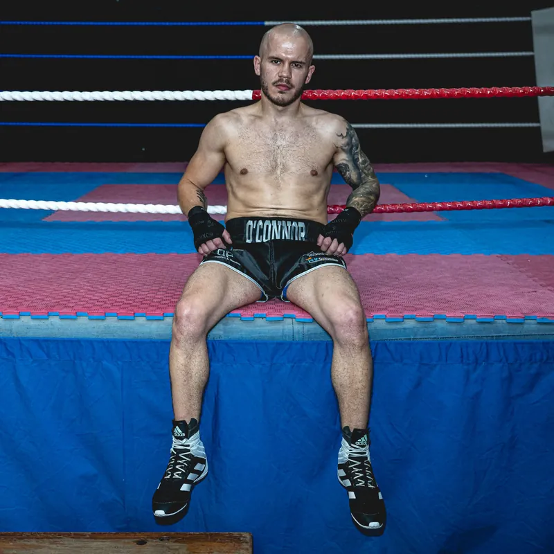 Bradley O'Connor sitting on the ring apron