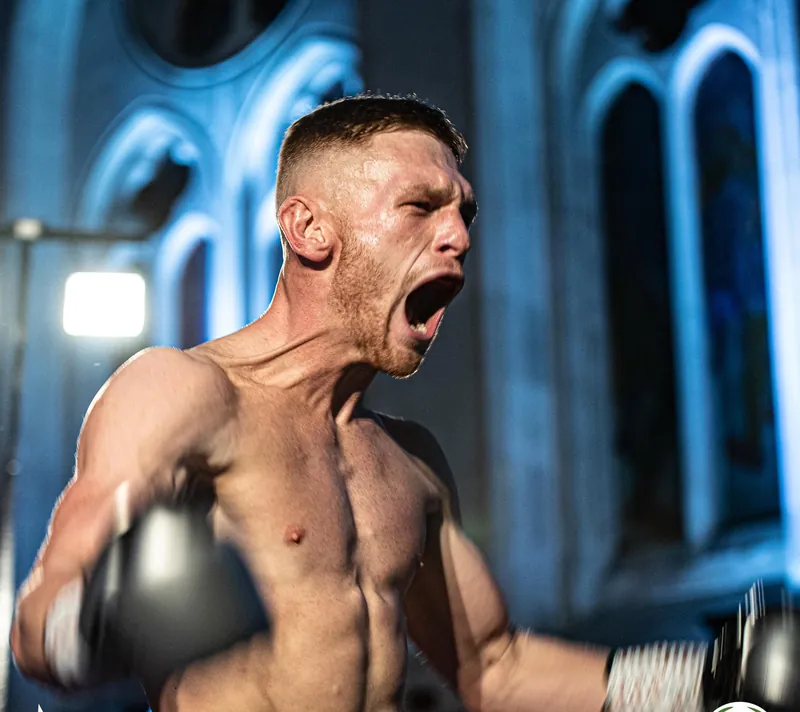 Lewis Everson roaring in the ring under blue lights