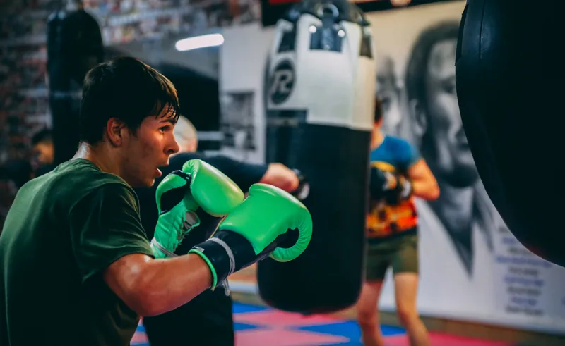 Constantin Ursu in green gloves throwing a jab at a heavy bag