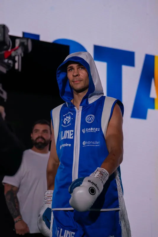 Constantin Ursu in a blue hooded robe and white gloves on his ring walk