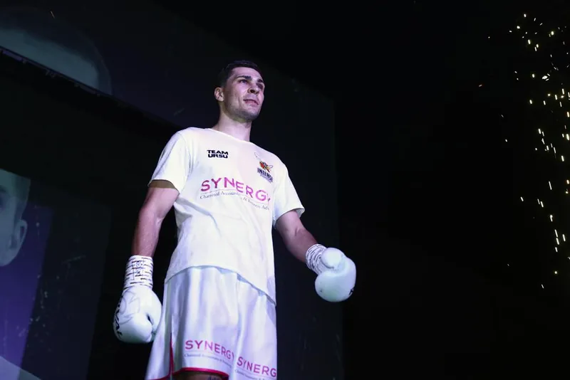 Constantin Ursu in white on a ring walk with sparklers behind him