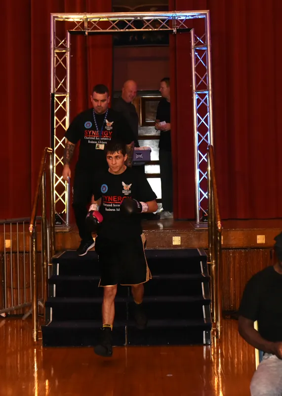 Constantin Ursu walks down the steps to the ring for his pro debut, with Marlee Dann behind him